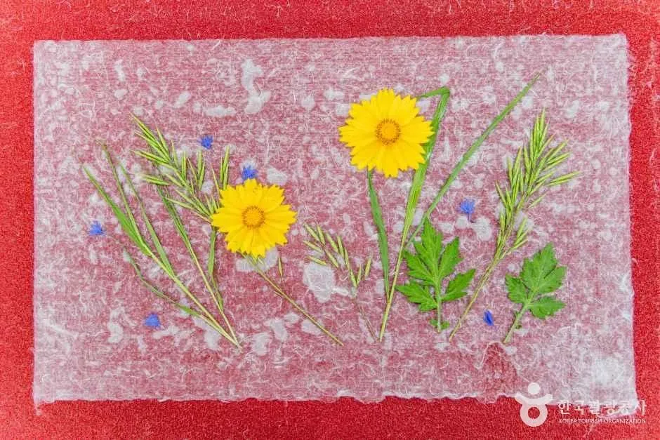 한지 위에 노란 꽃과 풀잎을 얹어 만든 야생화지