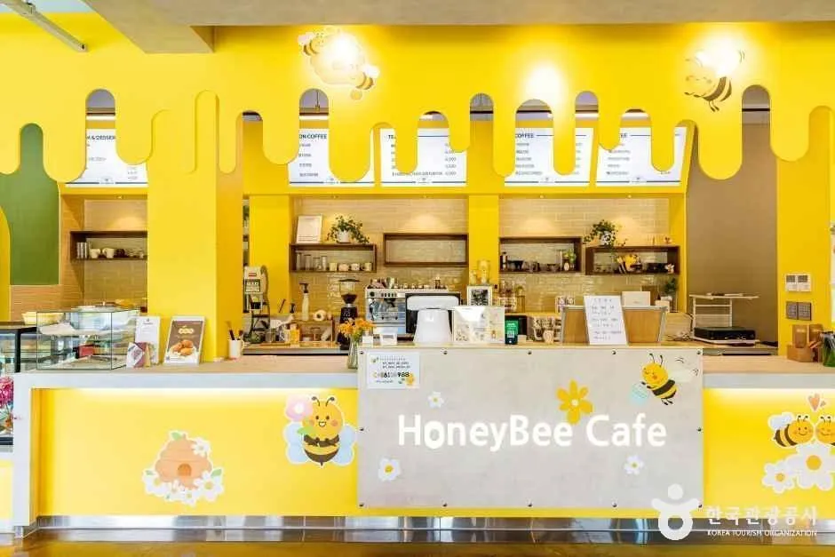 노란 벽에 꿀벌 그림을 붙인 꿀벌랜드 1층 'HoneyBee Cafe' 계산대
