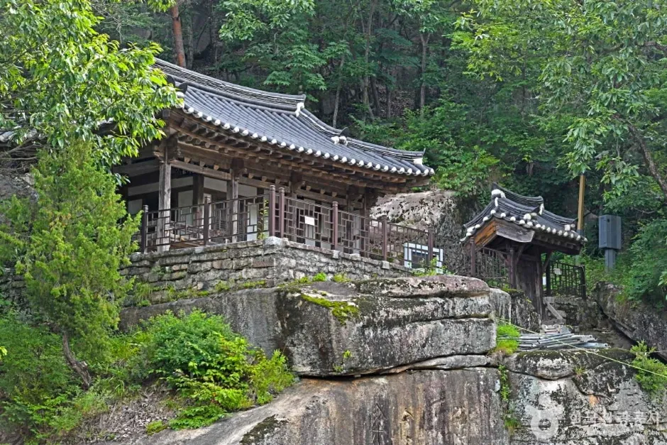 금사담 건너편 바위 벼랑 위에 선 암서재 기와 건물